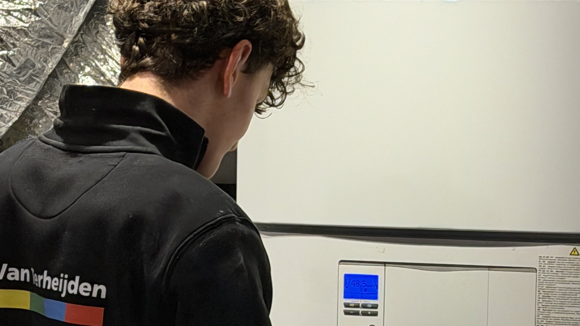 Monteur leest handleiding van Vaillant warmtepomp tijdens installatie